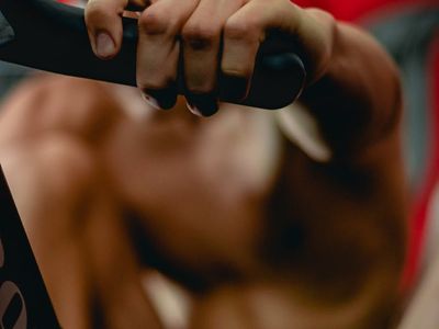 Close-up of a hand gripping a simple piece of workout equipment.