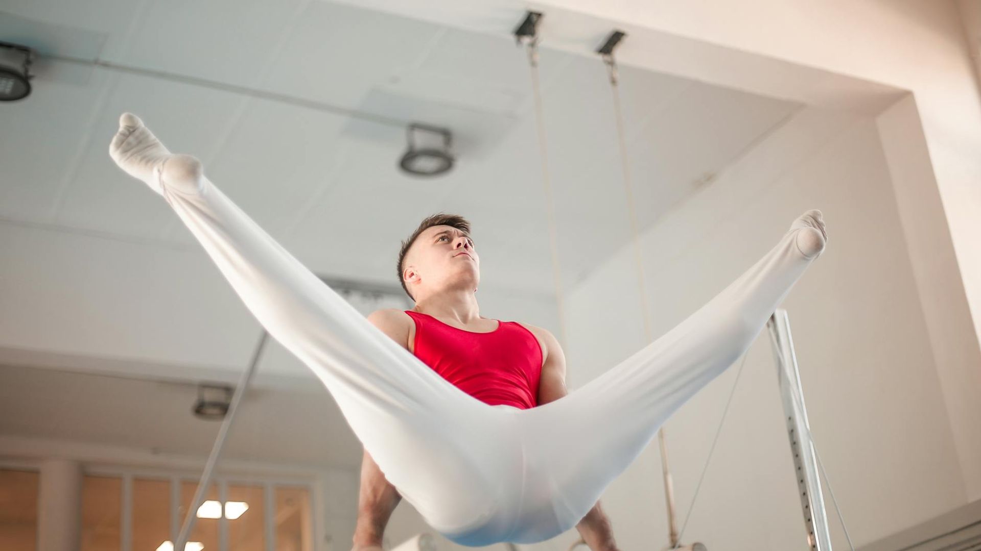 Man performing a controlled strength exercise in a dark, focused environment.